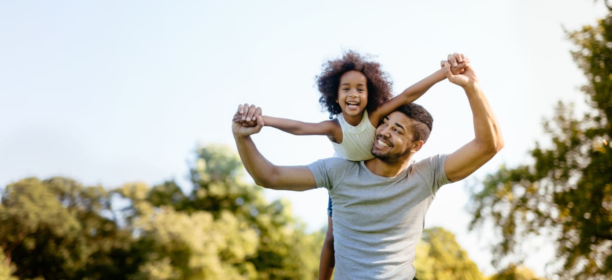 Happy father carrying is daughter on his shoulders