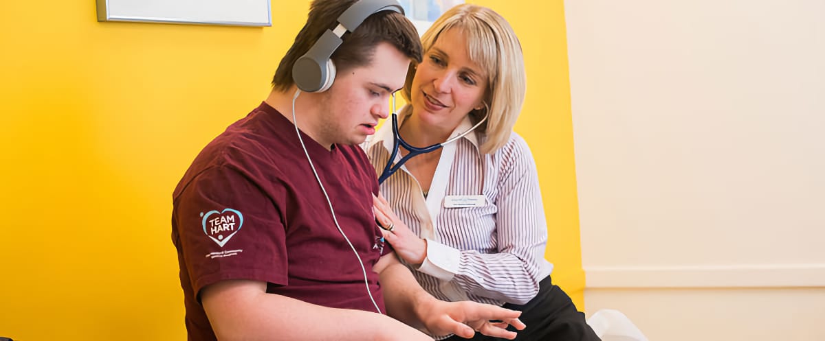 Dr. Schwab examines one of her patients, a young man with Down syndrome